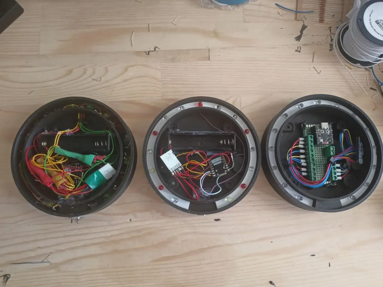 Three generations of the device's insides, from messy wiring to a clean circuit board