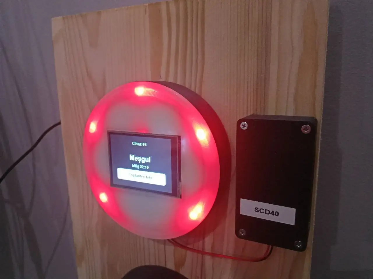 A custom status light glowing red, mounted by a factory staircase