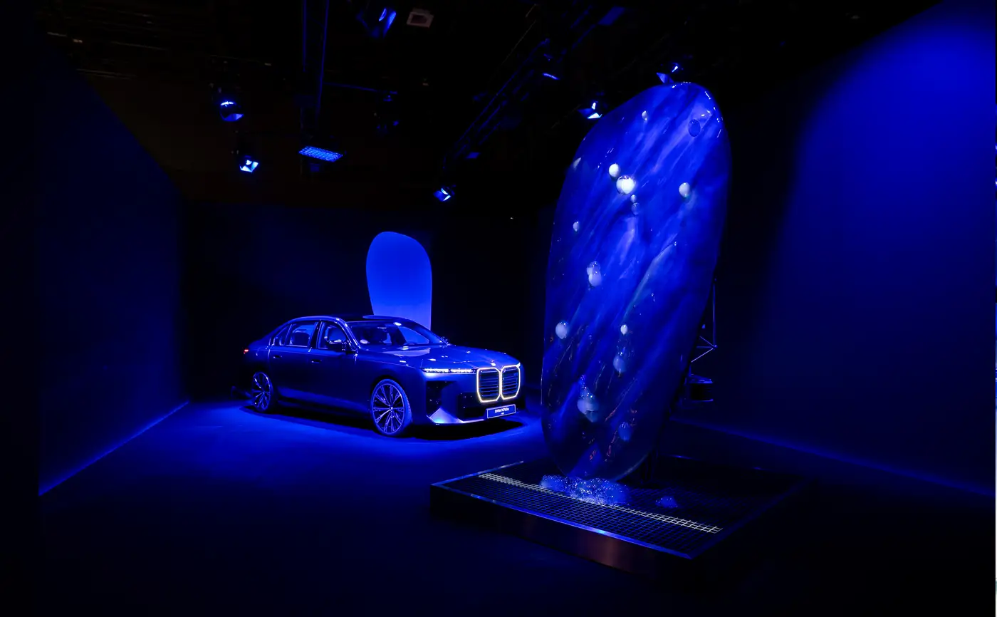 The Symbiosis sculpture lit blue in a dark exhibition room at Contemporary Istanbul